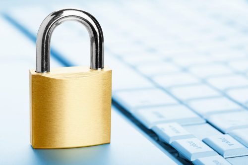 Padlock on laptop keyboard, close-up